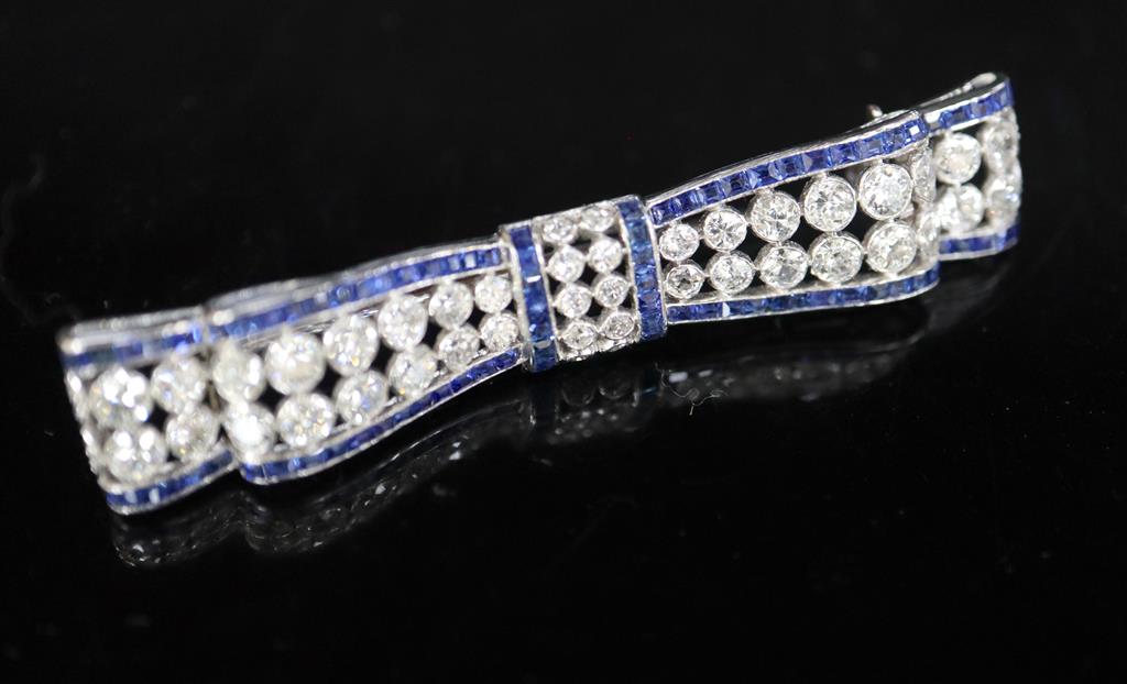 An Art Deco sapphire and diamond bow brooch mounted in white metal,